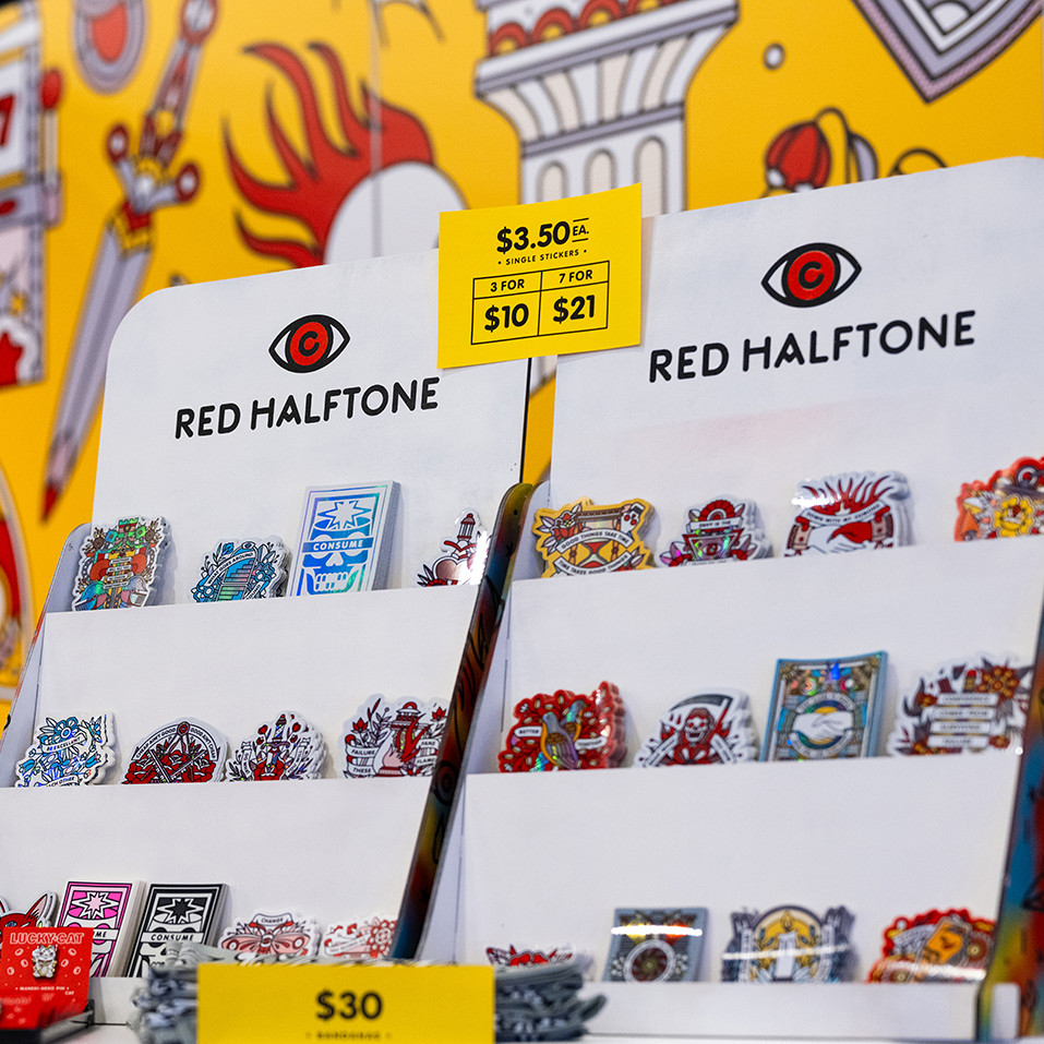 Display stand with colorful die-cut stickers from "Red Halftone" against a vibrant background.